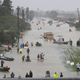 People walk down a flooded street as they evacuate their homes after the area was inundated with flooding from Hurricane Harvey on August 28, 2017 in Houston (Photo by Joe Raedle/Getty Images)